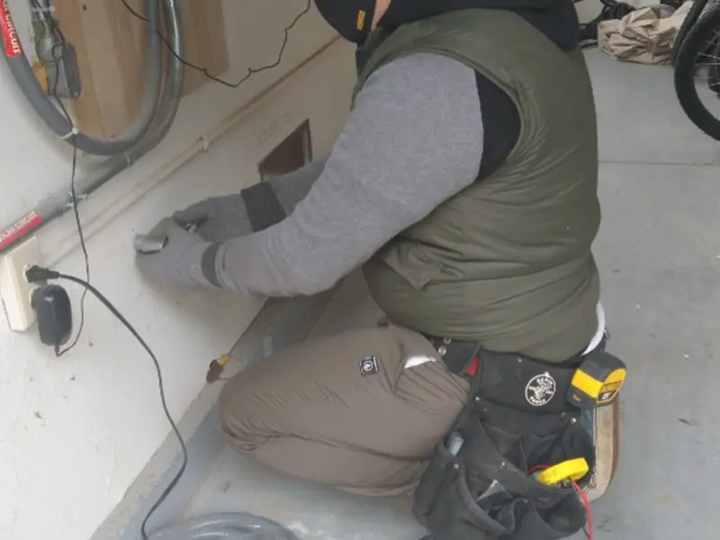 Electrician performing outlet wiring in a Bayou Cane garage